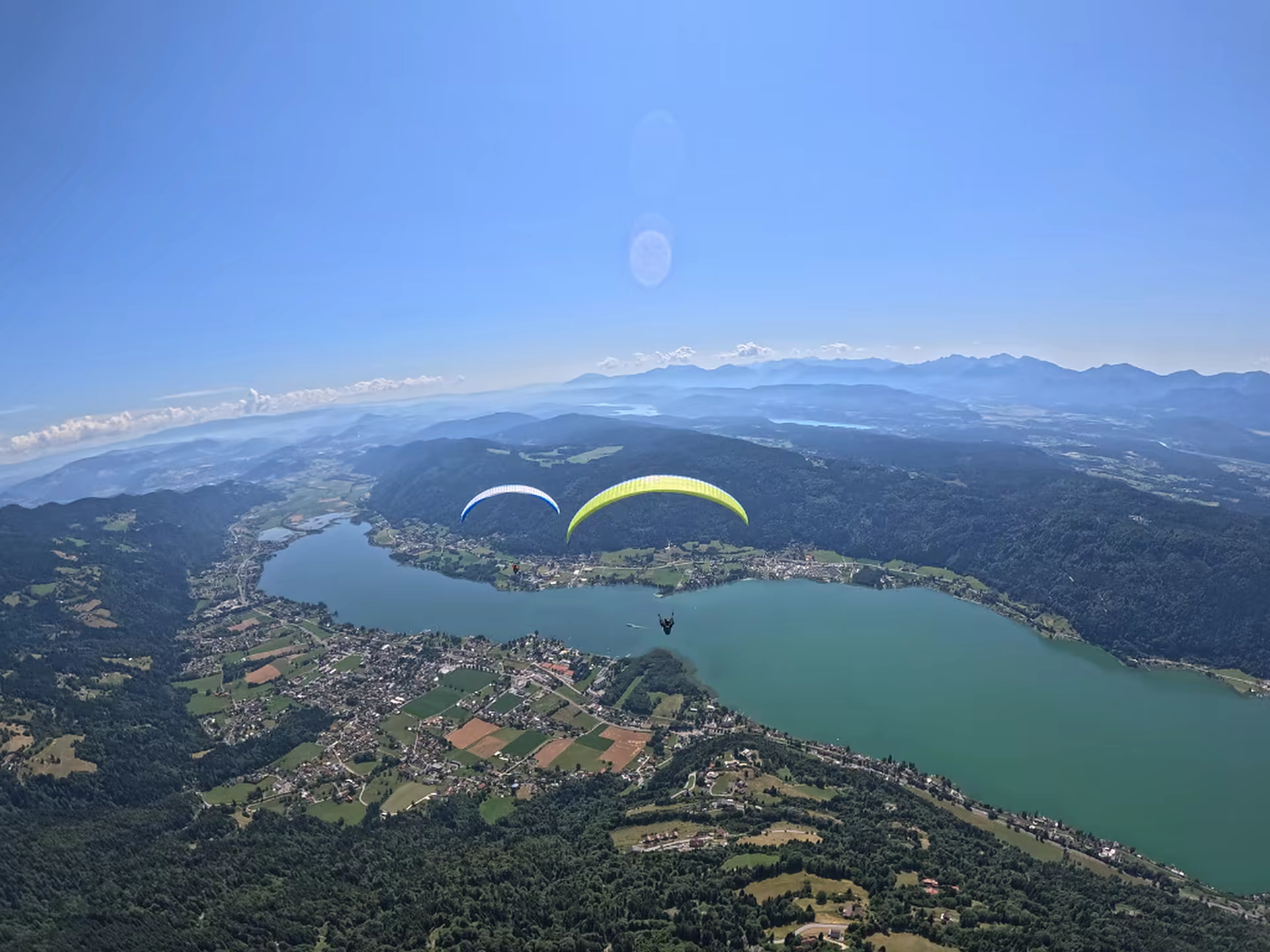 Zwei Tandem-Gleitschirme im Flug über dem Ossiacher See